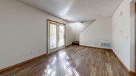 Located at 14008 Plymouth Ave in Burnsville, MN, this two-story home offers three bedrooms, three bathrooms, and a well-organized layout spread across two floors. The main level features a combination of hardwood-style flooring and textured ceilings throughout, giving the space a clean, functional feel. The kitchen is equipped with warm-toned natural wood cabinetry, a range, and a refrigerator, and connects to the dining area via a convenient pass-through window with a breakfast bar ledge — an efficient design that promotes an open flow between spaces. The living room extends toward a front entry door that allows natural light to filter in. Three bedrooms are carpeted and feature windows with outdoor views of surrounding greenery, providing a comfortable and quiet atmosphere. The spacious primary bedroom includes a generous walk-in closet outfitted with wire shelving for organized storage. The bathrooms feature tile flooring, vanities with wood cabinetry, and tub-shower combinations. Additional highlights include five closets total for ample storage, a utility room, a hallway, and an attached garage with a standard roll-up door and concrete flooring — well-suited for vehicle parking or additional storage needs.