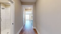 This 670 square foot single-floor living space offers a thoughtful blend of functionality and modern design. The open-concept layout seamlessly integrates the kitchen and living room, creating a spacious feel despite the compact footprint. Light-colored walls and recessed lighting contribute to a bright, airy atmosphere.

The space boasts durable wood-look flooring throughout, providing a warm and cohesive aesthetic. The kitchen area, partially visible in the image, features white upper cabinets and contrasting dark lower cabinets, adding visual interest and storage capacity. A hallway likely leads to two well-appointed bathrooms and a closet, optimizing the available space.

The living area is generously proportioned, offering ample room for furniture arrangement and daily activities. Clean lines and minimal architectural details create a contemporary ambiance, while the neutral color palette allows for personalized decorating. This efficient layout demonstrates clever space utilization, making it ideal for modern urban living or as a stylish starter home.