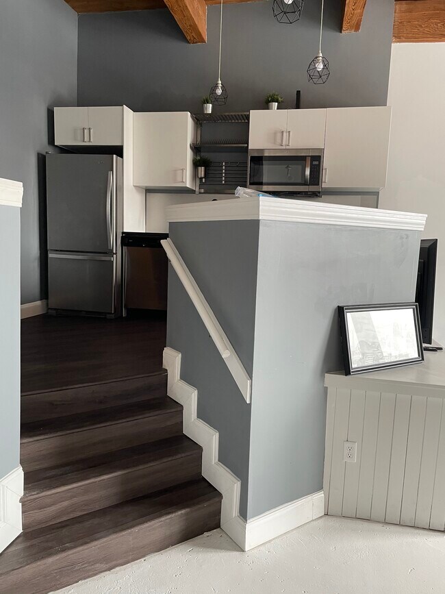 Stairs from the living room to the kitchen and bedroom area and private full bath - 308 W 8th St