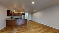 Located at 1115 Main St in Mukwonago, Wisconsin, this two-floor residence offers a well-designed layout with modern finishes throughout. The open-concept main living area seamlessly connects the kitchen and living space, creating a bright and functional environment. The kitchen is outfitted with rich dark wood cabinetry, granite-style countertops, stainless steel appliances including a refrigerator, electric range, and over-the-range microwave, and a peninsula with pendant lighting overhead. Hardwood-style flooring runs throughout the main living and kitchen areas, adding warmth and continuity to the space. The bedrooms are carpeted for comfort and feature ceiling fans and windows that bring in natural light. The bathrooms are finished with dark wood vanities topped with granite-style counters and wood-look flooring; one bathroom includes a walk-in shower, while the other offers a shower-tub combination. A dedicated laundry area with a stacked washer and dryer provides added in-unit convenience. The staircase connects the two floors, and the overall layout provides a practical flow between living, sleeping, and utility spaces throughout this clean, move-in-ready Mukwonago home.