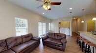 Located at 3607 University Blvd N in Jacksonville, Florida, this single-story residence offers a well-organized layout designed for comfortable everyday living. The interior is finished with warm neutral tones throughout, creating a cohesive and inviting atmosphere across all areas of the home.

The kitchen serves as a central highlight, featuring dark espresso cabinetry, granite countertops, stainless steel appliances including a range, microwave, and refrigerator, and a peninsula with pendant lighting overhead and bar seating for multiple guests. Wood-style plank flooring runs through the kitchen and main living areas, providing both durability and visual continuity.

The living room is generously sized, receiving natural light through multiple windows with blinds and a set of French doors that open to the outdoors. A ceiling fan adds to the room's comfort. Conveniently, an in-unit laundry area with washer and dryer hookups is accessible directly from the living space.

Bedrooms are carpeted and equipped with ceiling fans, offering a quiet and comfortable retreat. Natural light enters through windows with outdoor views of the surrounding greenery. The bathrooms feature wood-style flooring, tub-shower combinations with white tile surrounds, and dark vanity cabinetry. A hallway connects the various rooms, finished with the same wood-style flooring for a seamless flow throughout the home.