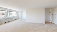 Located at 385 Ocean Blvd in Long Branch, NJ, this three-bedroom, one-bathroom residence offers a comfortable and functional layout across a single floor. The interior is finished with neutral-toned carpeting throughout, clean white walls, and bright white trim, creating a light and airy atmosphere.

The generously sized primary bedroom is notably expansive, featuring multiple closets with bi-fold doors for ample storage. Additional bedrooms are well-proportioned, each with large windows that invite natural light and offer views of the surrounding coastal cityscape, including glimpses of the ocean. Baseboard heating units are present in the windowed rooms, ensuring year-round comfort.

The bathroom is finished with elegant large-format tile on the walls and a mosaic accent border, complemented by a full soaking tub and shower combination with chrome fixtures and a built-in corner shelf — a clean and polished design overall.

The kitchen features warm wood cabinetry and is open to the main living area, supporting an efficient flow throughout the home. The living space is open and versatile, with windows framing outdoor views. A dedicated closet provides additional storage. The layout, as seen in the dollhouse view, is well-organized and maximizes the use of available space.
