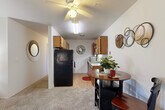 Located at 4394 Okemos Rd in Okemos, Michigan, this single-floor unit offers three bedrooms and one bathroom within a well-organized, efficiently laid-out floor plan. The living room serves as the heart of the home, featuring plush wall-to-wall carpeting and a large sliding glass door flanked by vertical blinds that flood the space with natural light and provide a direct view of the outdoors. The open connection between the living area and kitchen promotes an easy flow for everyday living. The kitchen is equipped with warm wood-toned cabinetry, a classic subway tile backsplash, a full-size refrigerator, and a sink with ample counter space. A ceiling fan with integrated lighting overhead adds both comfort and functionality to the combined living and dining area. Each of the three bedrooms is carpeted and features windows with vertical blinds, offering natural light and privacy. The primary bedroom is a comfortable size, providing room for standard furnishings. The secondary bedrooms are versatile spaces suitable for a variety of uses. The shared full bathroom includes a bathtub with shower and a single-sink vanity. Throughout the unit, the neutral color palette and clean finishes create a calm, practical living environment.