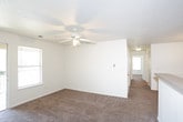This single-floor residence offers a practical and comfortable layout designed for everyday living. The open-concept living and dining area flows seamlessly into the kitchen, which features light wood cabinetry, a full suite of white appliances including a refrigerator, electric range, and built-in microwave, along with tile flooring and a peninsula breakfast bar that connects the kitchen to the carpeted living space. A pendant light fixture adds a subtle design touch above the dining area.

The bedrooms are carpeted throughout and share a consistent, clean aesthetic, each equipped with ceiling fans with light kits and windows fitted with blinds that allow for natural light and outdoor views. The rooms offer generous proportions suitable for a variety of furniture arrangements.

Both bathrooms are finished with tile flooring and feature full bathtub and shower combinations. The vanities include wood cabinetry with countertop sinks, providing practical storage. The overall color palette throughout the home is neutral, with white walls and warm-toned carpeting and tile, creating a bright and cohesive atmosphere. Textured ceilings and consistent trim work are present throughout, contributing to the home's well-maintained character.