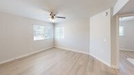 Located at 8028 S Central Ave in Phoenix, AZ, this single-story home offers three bedrooms and one bathroom within a thoughtfully arranged floor plan. Throughout the home, light wood-style laminate flooring and neutral beige walls create a clean, cohesive aesthetic that feels fresh and move-in ready. The combined kitchen and living area serves as the heart of the home, featuring warm honey-toned cabinetry, white countertops, a stainless steel Whirlpool range, and a center island with a sink — providing ample workspace and storage. The open layout allows for a natural flow between cooking and living areas. The primary bedroom is a comfortable size, benefiting from dual windows fitted with white blinds that invite natural light and offer outdoor views, complemented by a ceiling fan for year-round comfort. A dedicated walk-in closet with built-in shelving and hanging rods adds practical storage to the primary suite. The additional bedrooms are bright and versatile, each featuring light-filled windows with blinds. The full bathroom is efficiently designed, complete with a wood-toned vanity, white countertop, and a full tub-shower combination with a clean white surround and brushed nickel fixtures. Clean white six-panel interior doors and crisp baseboards finish the space with a polished look throughout.