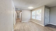 Located at 488 Lemont Dr in Nashville, TN, this single-floor 2-bedroom, 3-bathroom home offers a well-organized layout with modern finishes throughout. The living room welcomes you with wood-look laminate flooring, neutral gray walls, a textured ceiling, and a front-facing window that brings in natural light. The kitchen stands out with crisp white shaker cabinets, white subway tile backsplash, light quartz countertops, a stainless steel sink, and a dishwasher — combining style and functionality efficiently. A connecting hallway with light wood-look flooring links the main living areas to the bedrooms and bathrooms. Both bedrooms feature plush carpeting, ceiling fans, and closets, with the primary bedroom offering additional doors leading to an en-suite bathroom and extra storage. The bathrooms are cleanly finished with white vanity cabinets, subway tile accents, light wood-look tile flooring, and brushed nickel hardware. Windows in the bedrooms provide outdoor views and natural light. The overall aesthetic is consistent and contemporary, with a neutral gray-and-white palette, clean white trim, and updated fixtures carried throughout every room, creating a cohesive and move-in ready living environment.