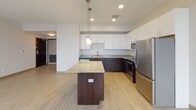 Located on N St Clair Street in Toledo, Ohio, this single-floor unit offers a thoughtfully designed layout with modern finishes and functional living spaces. The kitchen serves as a standout feature, showcasing granite countertops with warm tonal variation, a central island with matching stone surface, and a full suite of stainless steel appliances including a refrigerator, electric range, and over-the-range microwave. White upper cabinetry contrasts with dark espresso-toned lower cabinets, creating a contemporary two-tone aesthetic. Light wood-style flooring runs throughout the kitchen and living areas, complemented by recessed lighting and pendant fixtures above the island that add warmth to the space.

The bedroom is carpeted and finished with neutral-toned walls, dark baseboards, and a sliding closet door offering practical storage. The bathroom features wood-look tile flooring, a full tub and shower combination, a dark-cabinetry vanity with a light countertop, and clean, neutral wall finishes. Throughout the unit, the design balances modern aesthetics with everyday functionality, offering a cohesive and well-maintained living environment in downtown Toledo.
