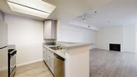 Located at 1335 N La Brea Ave in the heart of Hollywood, this well-appointed two-bedroom, two-bathroom unit offers a thoughtfully designed single-level layout. Light wood-style flooring flows consistently throughout, lending a clean, cohesive aesthetic to every room.

The open-concept kitchen is a functional highlight, featuring gray shaker cabinetry, granite-look countertops, stainless steel appliances including a gas range and refrigerator, a built-in dishwasher, and a breakfast bar peninsula that connects seamlessly to the living area. The kitchen also benefits from a skylight-style ceiling fixture that enhances natural brightness.

The living room is spacious and inviting, anchored by a fireplace and a ceiling fan, with sliding glass doors that open directly onto a private enclosed patio—ideal for outdoor relaxation. The patio is a generous size and provides a quiet outdoor retreat.

Both bedrooms are well-proportioned with neutral walls and ample natural light. The primary bedroom is notably spacious, supported by multiple closets throughout the unit offering excellent storage. Each bathroom is finished with granite-topped vanities, shaker-style cabinetry, and tub-shower combinations with glass enclosures. The overall design palette is neutral and modern, creating a bright, move-in-ready environment.