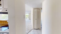 Located in Miami's 33172 zip code, this single-floor unit at 9020 NW Eighth St, Unit 308 features a well-organized layout with a blend of tile and carpeted flooring throughout. The living area is generously sized, bathed in natural light from large sliding glass doors that open onto a private balcony with outdoor views of surrounding greenery. A pendant light fixture anchors the adjacent dining area, which connects to the kitchen via a pass-through window.

The kitchen is equipped with white cabinetry featuring decorative trim detailing, warm wood-toned laminate countertops, a stainless steel sink, a dishwasher, and a window providing additional natural light and ventilation.

The bedroom offers ample storage with both a walk-in closet and an additional louvered-door closet, and benefits from its own window with natural light. The entry hallway also features a louvered bifold closet door, adding functional storage near the front of the unit.

The bathroom is finished with tile flooring, a tub-shower combination with tile surround accented by decorative inlays, a vanity with a stone-toned countertop, white cabinetry, and a large mirror. A textured ceiling is consistent throughout the unit. The overall ambiance is bright, clean, and functional.