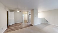 Located in Lynnwood, WA, this 2-bedroom, 1-bathroom unit offers a practical and comfortable layout designed for everyday living. The combined kitchen and living area serves as the heart of the home, with the kitchen showcasing grey shaker-style cabinetry, marble-look quartz countertops, stainless steel appliances including a refrigerator, range, and over-the-range microwave, and wood-style flooring. A ceiling fan overhead adds to the functional appeal. The living area extends seamlessly toward a sliding glass door that opens onto a private balcony, flooding the space with natural light and offering pleasant views of the surrounding greenery. Both bedrooms are carpeted and feature windows overlooking lush trees, creating a calm and natural atmosphere. The primary bedroom includes a sliding door closet with built-in rod storage. The full bathroom is clean and efficient, featuring a tub-shower combo with chrome fixtures and a marble-look countertop vanity. Neutral tones and warm beige walls throughout the unit lend a cohesive and inviting feel, making this a well-appointed home in a peaceful setting.