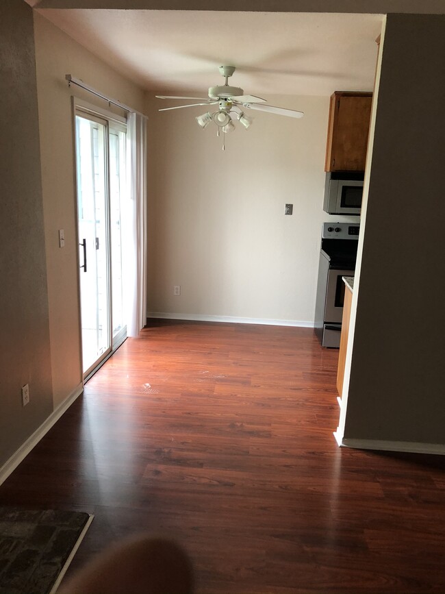 from the family room, looking into the kitchen with ceiling fan/light fixture, balcony and sliding door - 445 Almond Dr. #29