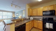 This single-floor residence at 3307 Autumn Dr in Tinton Falls, NJ offers a thoughtfully designed layout with a seamless flow between living, dining, and kitchen spaces. The open-concept living and dining area features neutral-toned walls, crown molding, and plush carpeting, creating a warm and inviting atmosphere. A large bay window fills the living room with generous natural light while offering pleasant outdoor views of surrounding greenery.

The kitchen is well-appointed with warm honey-toned cabinetry, dark granite-style countertops, and black appliances including a gas range, built-in microwave, refrigerator, and dishwasher. A peninsula with additional counter space connects the kitchen to the living and dining areas, making it practical for entertaining. Wood-style flooring adds a clean, durable touch to the kitchen space.

The bedrooms are carpeted and feature large windows that invite natural light, with one bedroom showcasing a cool-toned accent wall and elegant drapery. Both rooms offer a calm, restful ambiance suited for relaxation.

The bathroom includes a single vanity with wood cabinetry, a white countertop, a large mirror, and a full tub-shower combination, finished with tile flooring for easy maintenance. Overall, the residence presents a cohesive, comfortable living environment with practical features throughout.