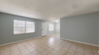 Located at 460 Hale Ave in Brooksville, Florida, this single-story 2-bedroom, 1-bathroom home offers a practical and well-organized layout. Light gray walls and neutral large-format tile flooring run consistently throughout the home, creating a clean, cohesive aesthetic.

The welcoming living room features multiple windows that allow natural light to fill the space, complemented by a classic white front door. Adjacent to the living area, a dedicated dining room provides a defined space for meals, while a hallway connects the main living areas to the private rooms.

The kitchen is a functional highlight, featuring white shaker-style cabinetry, granite countertops, stainless steel appliances including a range, microwave, and refrigerator, and tile flooring that continues from the main living areas.

Both bedrooms are well-proportioned and include ceiling fans, windows with blinds, and generous closet space — the home includes four closets in total. The spacious primary bedroom offers its own dedicated closet. The full bathroom is clean and straightforward, equipped with a tiled tub-shower combination.

A central hallway connects all rooms efficiently, and HVAC vents are present throughout, ensuring year-round comfort. This home offers a move-in ready, low-maintenance living environment in the heart of Brooksville.