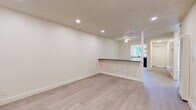 Located at 14950 Zelma St in San Leandro, CA, this 2-bedroom, 1-bathroom unit offers a well-organized single-floor layout with a clean, modern aesthetic throughout. Light-toned luxury vinyl plank flooring runs continuously across all rooms, lending a cohesive and fresh feel to the entire space.

The combined living and dining area is bright and open, illuminated by recessed lighting and a ceiling fan. A distinctive half-wall breakfast bar with a dark countertop separates this space from the kitchen, creating an efficient open-concept flow while maintaining definition between areas. A window at the far end brings in natural light and views of the surrounding greenery.

The kitchen is well-appointed with white shaker-style cabinetry, light countertops, a window above the sink, and stainless steel appliances including a dishwasher and range hood. A central hallway with four closets connects to the rest of the unit, offering ample storage throughout.

Both bedrooms are quiet and bright, each featuring windows with lush tree views, recessed lighting, and clean white walls. The primary bedroom is generously sized and sun-filled. The full bathroom features a tub/shower combination with white tile surround, a vanity with white cabinetry, and light flooring, maintaining the unit's consistent neutral palette.
