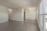 Located at 1587 Briarfield Rd in Hampton, Virginia, this single-floor residence is designed with functionality and simplicity in mind. Light wood-style flooring runs consistently throughout the entire unit, creating a cohesive and easy-to-maintain interior.

The open living area is spacious and bright, with white walls and neutral tones that provide a versatile backdrop for any furnishing style. A central dividing wall separates the living space from the adjacent areas, adding structural definition without sacrificing flow. The kitchen is efficiently laid out, featuring warm wood cabinetry, dark countertops, a sink, a white refrigerator, and a dishwasher — all within a compact, well-organized footprint.

The unit includes multiple bedrooms, each finished with the same light wood flooring, white walls, and ample closet space. One bedroom benefits from a large window that allows natural light to fill the room while offering a view of the surrounding neighborhood. Another bedroom is positioned adjacent to a bathroom, providing added convenience.

Two bathrooms serve the unit — one featuring a tiled shower-tub combination with a wood-toned vanity, and the other with a single vanity, mirror, and clean white fixtures. Both bathrooms continue the light flooring theme found throughout the home. Overall, the space presents a clean, move-in-ready environment well-suited for comfortable everyday living.