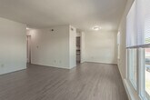 Located at 1587 Briarfield Rd in Hampton, Virginia, this single-floor residence is designed with functionality and simplicity in mind. Light wood-style flooring runs consistently throughout the entire unit, creating a cohesive and easy-to-maintain interior.

The open living area is spacious and bright, with white walls and neutral tones that provide a versatile backdrop for any furnishing style. A central dividing wall separates the living space from the adjacent areas, adding structural definition without sacrificing flow. The kitchen is efficiently laid out, featuring warm wood cabinetry, dark countertops, a sink, a white refrigerator, and a dishwasher — all within a compact, well-organized footprint.

The unit includes multiple bedrooms, each finished with the same light wood flooring, white walls, and ample closet space. One bedroom benefits from a large window that allows natural light to fill the room while offering a view of the surrounding neighborhood. Another bedroom is positioned adjacent to a bathroom, providing added convenience.

Two bathrooms serve the unit — one featuring a tiled shower-tub combination with a wood-toned vanity, and the other with a single vanity, mirror, and clean white fixtures. Both bathrooms continue the light flooring theme found throughout the home. Overall, the space presents a clean, move-in-ready environment well-suited for comfortable everyday living.