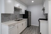 Located at 1776 N Sycamore Ave, Unit 207, in the heart of Los Angeles' vibrant Hollywood neighborhood, this thoughtfully updated residence offers a clean, modern aesthetic throughout. Light wood-style flooring flows seamlessly across all living areas, creating a cohesive and airy feel complemented by crisp white walls and recessed lighting.

The open living area provides generous room for furnishings and connects naturally to the kitchen, which features white shaker cabinetry, quartz countertops, a stainless steel undermount sink, a mosaic tile backsplash, and stainless steel appliances including a gas range and refrigerator. A breakfast bar adds convenience for casual dining.

The bedrooms are well-proportioned, each featuring large windows dressed with vertical blinds that allow for excellent natural light control. One bedroom includes a mirrored sliding-door closet, providing practical storage. Additional rooms offer similar bright, neutral environments adaptable to various uses.

The bathroom is finished to a high standard, featuring a tub-shower combination enclosed by a glass sliding door and clad in elegant marble-look tile with a built-in niche. A white vanity and coordinating flooring complete the polished look. The unit's overall design prioritizes clean lines, functionality, and a bright, welcoming ambiance throughout.