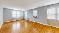 Located at 214 Price Ave in the desirable borough of Narberth, PA, this 2-bedroom, 1-bathroom home offers a well-designed single-floor layout with a cohesive and comfortable feel throughout. Warm hardwood floors run continuously through the living areas and bedrooms, complemented by soft gray walls and crisp white trim that create a clean, neutral palette.

The spacious living room is a standout feature, lined with multiple windows that invite abundant natural light. Radiator covers and wall-unit air conditioners provide year-round climate control. A distinctive arched entryway connects the living area to the hallway, adding an architectural charm that distinguishes the space.

The kitchen has been updated with dark wood cabinetry, granite countertops, a white subway tile backsplash, stainless steel appliances including a refrigerator and dishwasher, and light tile flooring — offering a modern contrast to the classic character of the rest of the home.

Both bedrooms are well-proportioned, each featuring hardwood floors, ceiling fans, windows with blinds, and closets. The primary bedroom comfortably accommodates standard bedroom furnishings.

The bathroom is neatly finished with large-format tile flooring, a tiled tub-shower surround, a granite-topped vanity, and a window for natural ventilation. A central hallway with closet access ties all rooms together efficiently.