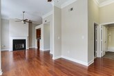 Located in Atlanta's 30327 zip code, this single-floor residence combines functional design with quality finishes throughout. Rich hardwood flooring flows seamlessly through the main living areas, complementing the neutral gray tones on the walls and crisp white crown molding and baseboards that add a polished architectural detail to each room.

The kitchen is thoughtfully equipped with warm-toned wood cabinetry, granite countertops, and a full suite of stainless steel appliances, including a range with overhead microwave and a French door refrigerator. A peninsula with additional counter space connects the kitchen to the adjacent dining area, which is accented by a classic chandelier overhead.

The living area is generously proportioned, featuring multiple large windows dressed with blinds that invite abundant natural light and views of the surrounding greenery. A ceiling fan adds both comfort and style to this bright, open space.

A separate bedroom area also benefits from a wide bank of windows overlooking neighboring architecture and tree canopy. Storage is well-addressed with a sizeable walk-in closet outfitted with wire shelving systems and carpeted flooring.

The bathroom is finished with wood-look tile flooring, a granite-topped wood vanity with brushed nickel hardware, and a full tub-shower combination with white tile surround, maintaining a cohesive and refined aesthetic throughout the home.
