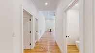 Located in Richmond's desirable Stuart Avenue corridor, this thoughtfully designed single-floor residence offers three bedrooms, four bathrooms, and a generous, well-appointed layout. Light hardwood floors run throughout, complementing the clean white walls and crown molding that lend a refined character to every room.

The living area is a standout, anchored by dramatic arched windows and French doors that flood the space with natural light and open to a private balcony overlooking lush, mature trees. The kitchen is a chef's showcase, featuring flat-front cabinetry in a warm natural wood tone, striking blue-grey granite countertops and backsplash, stainless steel double wall ovens, and a large island with an undermount sink and pendant lighting.

Wide, light-filled hallways connect the bedrooms, each served by well-sized closets with built-in shelving. The generously proportioned primary bedroom offers ample space for a full suite of furnishings. Four clean, modern bathrooms serve the home with understated elegance. A dedicated laundry room includes a side-by-side washer and dryer with overhead cabinetry for added storage. Recessed lighting throughout and ceiling fans complete this polished, move-in-ready home.