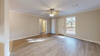 Located at 3020 Billy Jack Dr in Conway, Arkansas, this single-story, 3-bedroom, 2-bathroom home offers a well-organized layout across a comfortable footprint. The living room greets you at the entry with warm wood-look flooring, crown molding, and a ceiling fan, while a front-facing window fills the space with natural light and views of the surrounding greenery. The open entryway transitions smoothly into the rest of the home via a connecting hallway. The combined kitchen and dining area features warm oak cabinetry, tile flooring, a dishwasher, a refrigerator, and a double sink beneath a window — providing both function and a practical workspace. The primary bedroom is generously sized, benefiting from abundant natural light through large windows, a ceiling fan, and access to a dedicated closet with built-in shelving. The additional bedrooms are similarly appointed with ceiling fans and bright windows. Two full bathrooms serve the home, each with a tub-shower combination and tile flooring. A dedicated laundry room includes upper cabinetry and side-by-side washer and dryer units. The attached garage provides ample storage and parking space, equipped with an automatic opener. Four closets throughout the home ensure generous storage for all occupants.