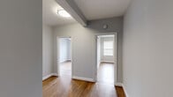 Located in Washington, DC's vibrant Rhode Island Avenue corridor, this two-bedroom, two-bathroom unit offers a thoughtfully designed single-level layout. Warm hardwood flooring runs throughout the main living areas and bedrooms, providing a cohesive aesthetic that ties the space together.

The kitchen is well-appointed with rich dark cabinetry, granite countertops, a white subway tile backsplash, and a full suite of stainless steel appliances, including a range, microwave, dishwasher, and refrigerator. An in-unit washer adds everyday convenience. The kitchen also benefits from natural light through a window overlooking the exterior.

Both bedrooms feature hardwood floors, neutral gray walls, and windows with blinds that allow natural light to filter in. The primary bedroom includes a wall-mounted split HVAC unit for individual climate control, while ceiling fans are present in multiple rooms. Two hallways and dedicated closets provide practical storage solutions throughout.

The full bathroom is finished with a dark granite vanity, tile flooring, a large mirror, and a shower-tub combination. A second bathroom offers additional convenience. The overall ambiance is clean, neutral, and move-in ready.
