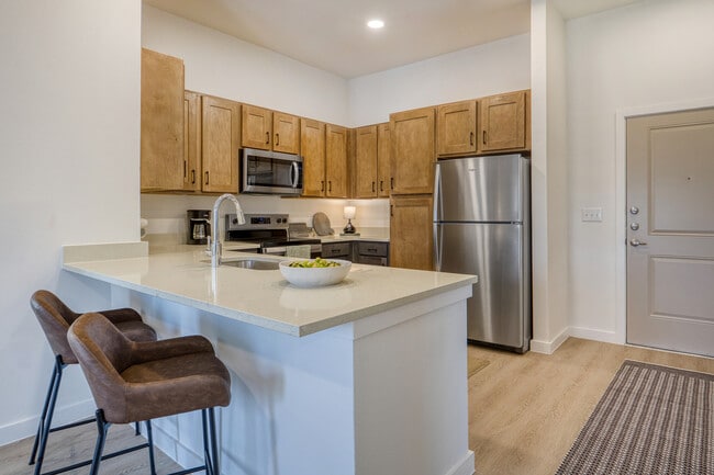 Spacious kitchen peninsula with convenient bar seating at Sageland Flats at Brooks - Sageland Flats at Brooks