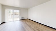Located at 2525 Highland Ave in National City, California, this studio unit offers a efficiently designed single-floor layout that makes excellent use of its intimate footprint. The space is characterized by clean white walls, dark baseboards, and warm wood-look vinyl plank flooring that runs throughout, creating a cohesive and modern aesthetic.

The open living area is bright and airy, benefiting from a full-height sliding glass door dressed with vertical blinds that allows natural light to pour in while providing outdoor views. A wall-mounted HVAC unit ensures year-round climate control. The living space flows seamlessly into a compact kitchenette area, which features warm wood-tone cabinetry, a white range, and a refrigerator — all efficiently arranged to maximize functionality.

A mirrored closet with gold-tone framing adds a sense of depth and reflects light throughout the space, enhancing the open feel. The entry area includes an electrical panel and a smoke detector, with a solid white entry door providing a clean, secure entryway. The neutral color palette and uncluttered design make this a versatile space well-suited for a variety of living arrangements.