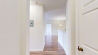Located on Summerhill Club Lane in Titusville, Florida, this well-appointed 2-bedroom, 3-bathroom single-floor residence offers a thoughtfully designed layout with a clean, bright aesthetic throughout. Wood-look flooring flows consistently across the living areas and bedrooms, complementing the crisp white walls and creating a cohesive, modern feel.

The entrance opens into a wide hallway that connects the main living areas. The open-plan dining and living room is bathed in natural light and features a decorative pendant light fixture that anchors the dining area. The kitchen is efficiently laid out in a galley style, equipped with stainless steel appliances including a refrigerator, range, microwave, and dishwasher, alongside warm-toned wood cabinetry and white countertops.

Both bedrooms are comfortably sized, with the primary bedroom offering a ceiling fan, a large window with outdoor views, and access to ample closet space, including a walk-in closet with wire shelving. Three full bathrooms include tub-shower combinations with white tile surrounds, wood-toned vanities, and tile flooring.

Additional highlights include a dedicated laundry area, multiple closets for generous storage, and a private balcony. The overall ambiance is light, clean, and functional, making this residence an practical and comfortable home.