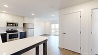 This 1-bedroom, 1-bathroom residence in Austin, TX offers a clean, contemporary design with an efficient and well-planned layout. Light wood-tone flooring flows throughout the space, complementing the bright white walls and recessed lighting that create a fresh, airy atmosphere.

The kitchen is a standout feature, showcasing a striking two-tone design with bold navy lower cabinets and crisp white upper cabinets, all paired with white quartz countertops. Stainless steel appliances — including a refrigerator, electric range, microwave, and dishwasher — complete the functional and stylish setup. A kitchen island provides additional prep and dining space. The kitchen opens seamlessly into the living area, which is bathed in natural light and leads to a private balcony through a sliding glass door.

The bedroom is a comfortable, well-lit retreat featuring windows with views of the surrounding area and a dedicated walk-in closet with built-in shelving for ample storage. Matte black door hardware adds a modern accent throughout.

The bathroom is finished with elegant marble-look tile surround in the tub/shower combination, wood-look flooring, and clean white fixtures, lending a polished and spa-like feel. This residence offers a cohesive modern aesthetic ideal for Austin living.