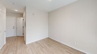 Located at 1420 E Howell St, Unit 210 in Seattle's vibrant Capitol Hill neighborhood, this thoughtfully designed studio offers a smart and efficient single-floor layout. The combined kitchen and living area forms the heart of the space, featuring light hardwood-style flooring, neutral walls, and a large floor-to-ceiling window that floods the room with natural light and provides views of the surrounding streetscape. The kitchen is well-appointed with dark espresso-toned cabinetry extending to the ceiling, stainless steel appliances including a refrigerator and built-in microwave, a sleek white countertop, an undermount sink, and a colorful mosaic tile backsplash that adds a lively design accent. The entrance hallway leads conveniently to the bathroom, which is finished with large-format gray tile flooring, a dark wood vanity with a white countertop, a full soaking tub with subway-tiled surround, and modern chrome fixtures. A dedicated closet provides practical storage. Recessed lighting throughout keeps the space bright and contemporary. The open, minimalist design aesthetic and quality finishes make this a highly functional and visually cohesive urban unit.