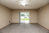 Located at 2325 University Dr in Muscatine, Iowa, this 2-bedroom, 1-bathroom single-floor unit offers a practical and comfortable layout. The living room is bright and welcoming, featuring plush carpet, a ceiling fan with light fixture, and a sliding glass door that fills the space with natural light while providing views of the surrounding greenery. The well-appointed kitchen is a functional highlight, equipped with warm oak cabinetry, white laminate countertops, a double-basin stainless steel sink, a peninsula for additional prep or dining space, and a full suite of white appliances including a refrigerator, range, microwave, and dishwasher. Light hardwood-style flooring adds warmth to the kitchen area. Both bedrooms are carpeted and feature natural light from windows, warm neutral-toned walls, and wood-trimmed doors. The primary bedroom includes a double-door closet, offering ample storage. The bathroom is equipped with hardwood-style flooring, a combination tub and shower, and clean white fixtures. Additional storage is provided throughout via multiple closets. A dedicated laundry area, connecting hallway, and a textured ceiling finish complete this well-organized and efficiently designed space.