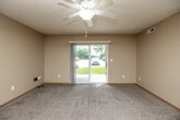 Located at 2325 University Dr in Muscatine, Iowa, this 2-bedroom, 1-bathroom single-floor unit offers a practical and comfortable layout. The living room is bright and welcoming, featuring plush carpet, a ceiling fan with light fixture, and a sliding glass door that fills the space with natural light while providing views of the surrounding greenery. The well-appointed kitchen is a functional highlight, equipped with warm oak cabinetry, white laminate countertops, a double-basin stainless steel sink, a peninsula for additional prep or dining space, and a full suite of white appliances including a refrigerator, range, microwave, and dishwasher. Light hardwood-style flooring adds warmth to the kitchen area. Both bedrooms are carpeted and feature natural light from windows, warm neutral-toned walls, and wood-trimmed doors. The primary bedroom includes a double-door closet, offering ample storage. The bathroom is equipped with hardwood-style flooring, a combination tub and shower, and clean white fixtures. Additional storage is provided throughout via multiple closets. A dedicated laundry area, connecting hallway, and a textured ceiling finish complete this well-organized and efficiently designed space.