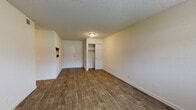 Located at 5101 Linbar Dr in Nashville, TN, this single-floor unit offers a clean, functional layout designed for comfortable everyday living. The main living area features durable wood-look plank flooring and neutral-toned walls, creating a bright and versatile space. A closet with built-in shelving and hanging rods provides convenient storage directly off the living area. The kitchen is well-appointed with dark espresso cabinetry, granite-style countertops, and wood-look flooring that ties seamlessly into the rest of the main living space. A passthrough opening connects the kitchen to the adjoining area, enhancing the open feel of the layout. The bedrooms are finished with plush carpeting and feature natural light from blinds-equipped windows, along with dedicated closet space. One bedroom includes a spacious walk-in closet with dual hanging rods and shelving. The bathroom is outfitted with matching dark cabinetry, a granite-style vanity top, overhead storage, and a full tub-shower combination with wood-look flooring. Textured ceilings throughout add a classic finishing touch to this well-maintained Nashville residence.