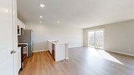 This single-story, 4-bedroom, 2-bathroom home in Elkhorn, Nebraska offers a clean and modern design throughout. The open-concept living and kitchen area serves as the heart of the home, featuring light wood-style flooring, recessed lighting, and neutral tones that create a bright and welcoming atmosphere. The kitchen is well-appointed with white shaker-style cabinetry, light countertops, and a full suite of stainless steel appliances including a range, over-the-range microwave, dishwasher, and refrigerator. A kitchen peninsula provides additional prep space and separates the kitchen from the expansive living area, which is bathed in natural light from large sliding glass doors and windows that offer views of the surrounding neighborhood. The four bedrooms are comfortably sized, with plush carpeting and individual closets offering ample storage. The primary bedroom is generously proportioned and includes a dedicated closet and private en-suite bathroom. The two bathrooms feature clean, functional finishes including wood-style flooring and a tub-shower combination. A dedicated laundry room houses a full-size washer and dryer. Two hallways connect the layout efficiently, making this home a practical and comfortable single-level residence.