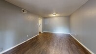 Located at 4000 Rio Lobo Dr in Memphis, TN, this one-bedroom, two-bathroom home offers a practical and well-organized single-floor layout. Dark hardwood-style flooring runs consistently throughout the living areas and bedroom, complemented by neutral gray walls and textured ceilings that create a cohesive aesthetic.

The living room is a comfortable open space featuring a sliding glass door with vertical blinds that allows natural light to filter in and provides access to an outdoor patio area, which is surrounded by mature trees and features a brick-laid surface. The kitchen is equipped with white cabinetry, granite-patterned countertops, and a freestanding electric range with an overhead ventilation hood, offering efficient use of space.

The spacious primary bedroom includes a window with blinds that brings in natural light and an adjacent door providing convenient access to one of the bathrooms. Both bathrooms are functional in design: one features a single-basin vanity with dark countertops and white cabinetry topped by a large mirror and lighted fixture, while the second includes a full tub-and-shower combination with white tile surround. Together, these elements make for a straightforward and well-appointed home.