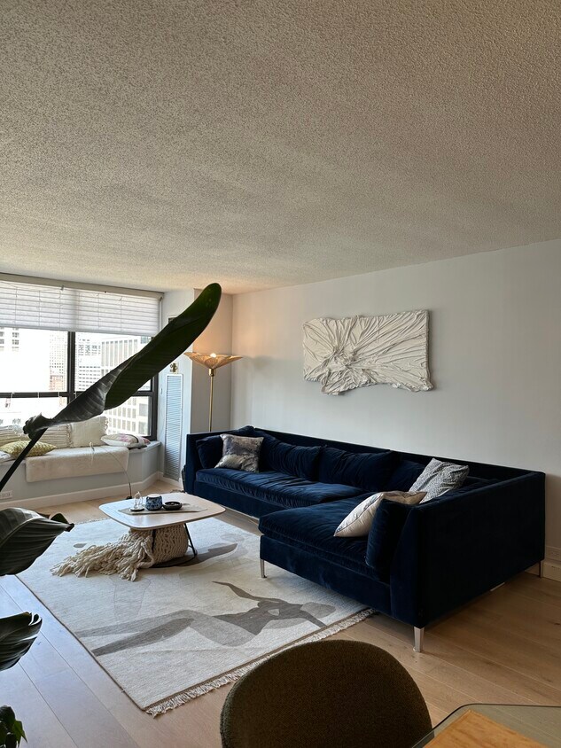 Furnished. Open living room with designer furniture and high end TV. Hand made designer art - 405 N Wabash Ave