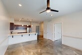Located at 1400 SW Railroad Ave in Hammond, Louisiana, this one-bedroom, one-bathroom unit offers a thoughtfully designed open-concept layout that maximizes its efficient footprint. Polished concrete floors flow seamlessly throughout the entire space, lending a contemporary industrial character while remaining easy to maintain.

The kitchen is a standout feature, showcasing rich dark-wood cabinetry, crisp white quartz countertops, and a full suite of stainless steel appliances including a refrigerator, electric range, built-in microwave, and dishwasher. A peninsula with bar-height seating bridges the kitchen and living area, making it ideal for casual dining or entertaining. Pendant lighting above the peninsula adds a refined touch, complementing the recessed lighting found throughout.

The open living and dining area is generously proportioned, filled with natural light from large windows, and equipped with a ceiling fan for year-round comfort. The bedroom offers a comfortable, well-lit retreat with its own ceiling fan, a window overlooking the outdoors, and direct access to adjacent spaces. The bathroom is clean and functional, featuring a dark-wood vanity with a white countertop, a tub-shower combination, and brushed nickel fixtures throughout.