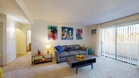 Located at 7100 E Mississippi Ave in Denver, Colorado, this one-bedroom, one-bathroom residence offers a well-organized single-floor layout with a practical mix of living spaces. The carpeted living room is bright and inviting, featuring a sliding glass door that opens to a private balcony, filling the space with natural light. A wall-mounted AC unit provides climate control, complementing the baseboard heating throughout. The living area flows naturally into a separate dining room, which is accented by a ceiling fan and connects conveniently to the kitchen. The kitchen features warm wood cabinetry, granite-style countertops, a double sink, and wood-look flooring, providing a functional cooking environment. The bedroom offers comfortable carpeting, a textured ceiling, and a large window that brings in natural light, along with generous closet storage—four closets are distributed throughout the unit for ample organization. The bathroom includes a full tub-shower combination with clean white tile finishes and wood-look flooring. A hallway connects the rooms efficiently, completing this thoughtfully arranged home well-suited for comfortable Denver living.