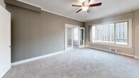 Located in Seattle's vibrant Belltown neighborhood, this one-bedroom, one-bathroom unit offers a practical and well-organized layout across a single floor. The combined living and dining area is carpeted and bathed in natural light through large windows that frame urban city views of the surrounding skyline. A ceiling fan adds comfort, and crown molding lends a refined touch throughout. French doors lead from the living area, enhancing the sense of openness.

The kitchen features warm hardwood flooring, white shaker-style cabinetry, stainless steel appliances including a refrigerator, electric range, and dishwasher, along with ample storage — a functional space for everyday cooking.

The bedroom is a quiet, carpeted retreat with crown molding, a ceiling fan, and multiple windows providing city views and natural light. A dedicated closet with built-in shelving offers organized storage. Additional closets throughout the unit provide further flexibility.

The bathroom is cleanly appointed with a pedestal sink, a tub/shower combo with a curved rod, a large mirror, and a well-lit vanity. Neutral tones and tile flooring create a crisp, functional finish. A hallway connects all rooms, completing this efficiently designed urban residence.