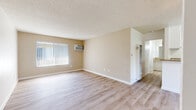 Located at 727 S Lyon St in Santa Ana, CA, this one-bedroom, two-bathroom residence offers a well-organized single-floor layout designed for comfortable everyday living. Light wood-style flooring flows consistently throughout, brightening the space and creating a cohesive aesthetic from room to room. The open living area features textured ceilings, neutral warm-toned walls, and large windows dressed with vertical blinds that allow natural light to fill the room. A wall-mounted air conditioning unit provides climate control directly in the living space. The kitchen is efficiently laid out with white cabinetry, granite-style countertops, a gas range, built-in microwave, and ample upper and lower cabinet storage — all finished in a clean, classic style. The bedroom offers a comfortable footprint with a window overlooking the exterior, wall-mounted air conditioning, and light flooring consistent with the rest of the unit. The two bathrooms are finished with white cabinetry, granite-style countertops, and clean white fixtures, including a tub-shower combination with a handheld showerhead. Hallway access connects the living areas to the bathrooms seamlessly. The overall ambiance is clean, bright, and functional, making this a practical and well-maintained residence in a convenient Southern California location.