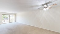 This 2-bedroom, 2-bathroom residence at 625 S Dilger Ave in Waukegan, Illinois offers a practical and comfortable single-floor layout. The open living room is carpeted and bathed in natural light from a large sliding glass door that leads to a private balcony, providing pleasant outdoor views. A ceiling fan adds comfort to the living area, which flows easily through the unit's well-organized floor plan.

The kitchen is efficiently designed with cream-toned cabinetry, dark granite countertops, stainless steel appliances including a gas range, built-in microwave, and a large refrigerator. Dark tile flooring grounds the kitchen space, which also includes a closet for additional storage.

Both bedrooms are carpeted and feature ceiling fans, offering a cozy atmosphere. The primary bedroom is generously sized, with access to a closet. Windows in the bedrooms frame views of surrounding greenery, bringing in natural light and a connection to the outdoors. Baseboard heating is present throughout.

The bathrooms are functionally appointed; one features a walk-in glass-door shower, patterned tile flooring, warm wood cabinetry, and tiled walls. The overall aesthetic of the unit is clean and neutral, with white walls throughout that create a bright, move-in-ready environment.
