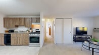 Located at 479 S Broadway in Lawrence, MA, this 2-bedroom, 1-bathroom unit offers a thoughtfully arranged single-floor layout that maximizes every square foot of its compact footprint. The open-concept kitchen is a standout feature, equipped with warm-toned wood cabinetry, granite-style countertops, a stainless steel gas range, a dishwasher, and a full-size refrigerator. Tile flooring runs throughout the kitchen and dining area, which provides ample space for a full dining set. The living room is bright and welcoming, featuring plush carpeting, multiple windows that allow natural light to fill the space, and a relaxed, comfortable atmosphere. A hallway connects the main living areas to the two bedrooms, each finished with soft carpet flooring. The primary bedroom is a well-sized retreat with a large window and generous natural light. The second bedroom includes a built-in closet with sliding doors for convenient storage. The bathroom is clean and functional, featuring a wood-toned vanity with a mirrored medicine cabinet. Throughout the unit, neutral walls and light finishes create a cohesive and understated aesthetic suited to a variety of personal styles.