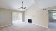 Located at 3214 Brassfield Rd in Greensboro, NC, this one-bedroom, one-bathroom residence offers a well-organized single-floor layout with thoughtful design details throughout. The living room is a standout, boasting soaring vaulted ceilings, a ceiling fan, a classic fireplace with a floating mantel shelf, and a sliding glass door that floods the space with natural light and provides views of lush greenery outside. Soft carpet underfoot adds warmth and comfort to this inviting area. The kitchen is thoroughly updated, featuring white shaker cabinets with matte black hardware, marble-look countertops, a subway tile backsplash, stainless steel appliances, and a peninsula with a stainless sink — all set atop light wood-look flooring. A dedicated entrance and hallway connect the main living areas to the generously sized bedroom, which offers vaulted ceilings, plush carpet, a ceiling fan, a walk-in closet, and direct access to the full bathroom. The bathroom includes a tub/shower combination with wood-look flooring. A conveniently located in-unit laundry area with shelving above completes this efficiently designed home.