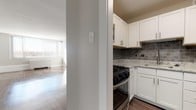 Located at 2000 Riverside Dr in Richmond, Virginia, this single-floor residence offers a clean, modern aesthetic with thoughtfully updated finishes throughout. The living area is bathed in natural light from large, wide windows fitted with horizontal blinds, showcasing gleaming hardwood-style flooring that extends seamlessly across the space. A stylish sliding barn door with dark wood framing and frosted glass panels serves as a distinctive architectural accent, adding character to the interior.

The kitchen is well-equipped and contemporary, featuring crisp white shaker-style cabinetry, granite countertops, and a gray subway tile backsplash. Stainless steel appliances — including a gas range and refrigerator — complete the functional cooking space, which connects openly to the main living area.

The bedroom is comfortably sized and includes a wide double-door closet, providing ample storage. Neutral, light gray walls and the consistent hardwood-style flooring lend a cohesive and calming tone throughout. The bathroom is efficiently laid out, featuring a sliding glass-door shower enclosure, toilet, and vanity with clean white finishes. The overall ambiance of the residence is bright, modern, and move-in ready, making it a practical and attractive living space in Richmond's Riverside Drive corridor.
