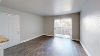 Located at 7879 Riverfall Dr in Dallas, TX, this single-story, 1-bedroom, 2-bathroom home offers a practical and well-organized layout. Wood-look flooring runs throughout the space, complemented by neutral gray walls and clean white baseboards that create a bright, cohesive aesthetic.

The open-concept living, dining, and kitchen area forms the heart of the home. The living room features a textured ceiling, a sliding glass door fitted with vertical blinds, and direct access to a private patio, allowing natural light to fill the space. The kitchen is efficiently designed with granite countertops, a tile backsplash, and stainless steel appliances, with a pass-through counter that connects it to the living and dining area. A dedicated pantry provides additional storage.

The bedroom is comfortably sized, featuring a window with natural light, a closet, and the same consistent wood-look flooring. A hallway connects the bedroom to the two bathrooms, one of which includes a full tub-shower combination with white tile surround. Two closets throughout the home offer practical storage solutions.

The textured ceilings, neutral color palette, and consistent finishes throughout lend the space a clean, move-in-ready feel suited for comfortable everyday living.