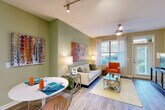 Located at 2345 Peachwood Cir NE in Atlanta, GA, this 2-bedroom, 2-bathroom residence offers a thoughtfully designed single-floor layout. The open-concept living and dining area is highlighted by wood-style flooring, sage green accent walls, track lighting, and large windows that invite abundant natural light. The kitchen is well-equipped with dark espresso cabinetry, granite countertops, stainless steel appliances including a dishwasher, range, microwave, and refrigerator, complemented by tile flooring and pendant lighting over a central island that opens to the living space. Both bathrooms feature granite-topped vanities with dark cabinetry and tiled tub-shower combinations. The primary bedroom offers plush carpeting, a walk-in closet with wire shelving, and a large window with outdoor views. The second bedroom is equally comfortable, also featuring carpeted floors and a window with natural light. Two dedicated closets and two hallways provide practical storage and circulation throughout. The overall ambiance is warm and contemporary, combining neutral tones with colorful accent details for a welcoming atmosphere.