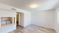 Located at 3040 N 35th Ave in Phoenix, Arizona, this single-story unit offers a practical and efficiently designed layout comprising a living room, one bedroom, one bathroom, and a closet. Throughout the unit, light-toned wood-look flooring provides a clean, cohesive aesthetic that ties each room together. The living room is a bright, open space featuring a textured ceiling, a multi-bulb ceiling light fixture, and a large window fitted with vertical blinds that allow for natural light and privacy control. A built-in counter or shelf element is also visible, adding a functional touch to the area. The bedroom is well-proportioned and includes a ceiling fan with a light fixture, a sliding window that brings in natural light and outdoor views, and direct access to the closet. Textured ceilings and crisp white walls are consistent throughout, contributing to a clean and airy feel. The bathroom is straightforward and functional, equipped with a bathtub and shower surround, a toilet, and a grab bar for added convenience. HVAC venting is present in the bedroom, ensuring year-round comfort suited to the Phoenix climate. Overall, the unit presents a no-frills, move-in-ready space with a bright, neutral palette.
