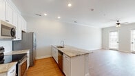This single-story residence in Southaven, Mississippi, delivers a clean, modern aesthetic with an open-concept floor plan designed for comfortable everyday living. Warm hardwood-style flooring flows consistently throughout the home, unifying each space with a cohesive look.

The kitchen serves as a central hub, featuring white shaker cabinetry extending to the ceiling, marble-look countertops, and a full suite of stainless steel appliances including a range, microwave, dishwasher, and refrigerator. A peninsula with an integrated sink and seating overhang connects seamlessly to the open living area, which is bathed in natural light from a pair of glass doors leading to the exterior. Crown molding and a ceiling fan add refined finishing touches to the living space.

Both bedrooms are generously sized, each featuring ceiling fans and windows that invite ample natural light and outdoor views. The primary bedroom includes a walk-in closet and direct access to a private en-suite bathroom with a glass-enclosed walk-in shower and tile surround. A second full bathroom offers a tiled tub-shower combination with sliding glass doors. Additional practical features include an in-unit laundry area accessible from the secondary bedroom, providing added convenience within this well-designed home.