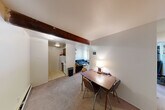 Located at 912 Brown St in Ann Arbor, Michigan, this two-bedroom, one-bathroom unit offers a compact and functional single-floor layout. The open living and dining area serves as the heart of the home, featuring carpet flooring, a distinctive exposed wood beam overhead, and an adjoining kitchen with tile flooring and standard appliances including a refrigerator and range. A balcony provides a welcome touch of outdoor access.

Both bedrooms are carpeted and offer ample natural light through large windows. The primary bedroom includes an open built-in closet with shelving and hanging space, with convenient access to the shared bathroom. The second bedroom also features its own closet. In total, the unit includes three closets, providing generous storage throughout. A hallway connects the main living areas to the bedrooms, adding a sense of separation and privacy.

The shared bathroom is straightforward and functional, featuring a vanity with sink, mirror, and a combined tub/shower. The overall layout is efficient, making practical use of the available space. With its proximity to the University of Michigan campus, this unit is well-suited for students or young professionals seeking a comfortable and conveniently located residence in Ann Arbor.